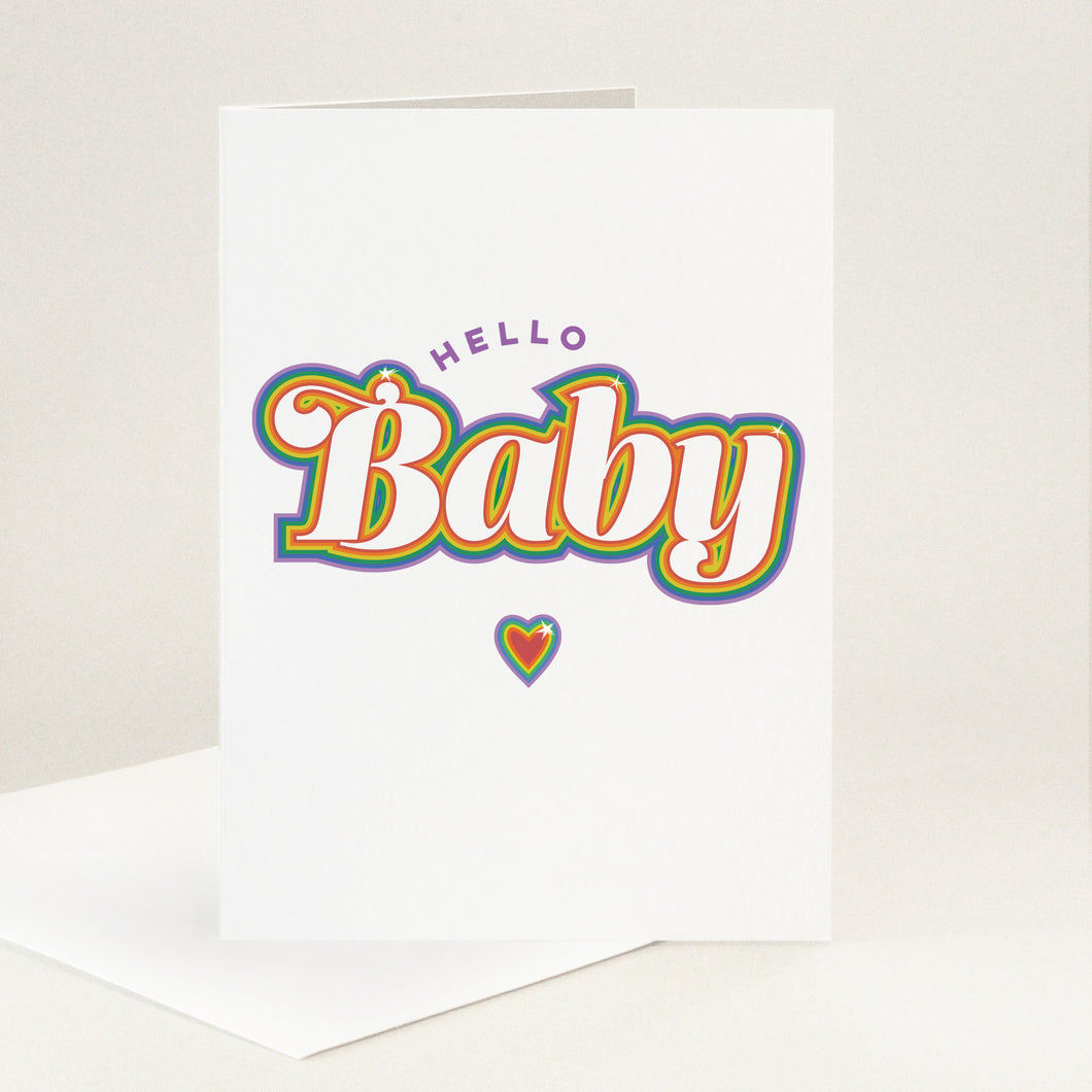 Little purple Hello in an arc above Baby in retro-style lettering with a multicolour rainbow outline and heart below it.