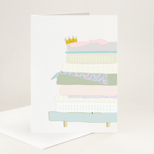 Load image into Gallery viewer, A gold crown sits atop 8 mattresses piled high on a bed with a tiny pea under one! Muted colours and  plain for your message.
