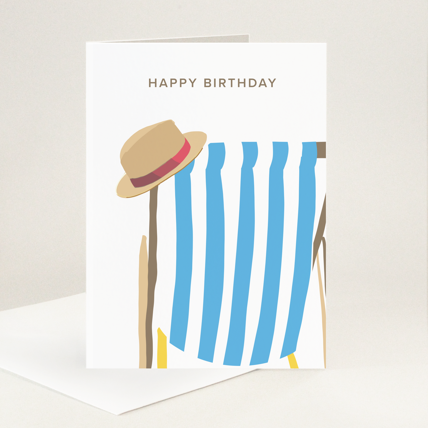 Happy Birthday message above a blue and white striped deckchair with a summer hat perched on the top